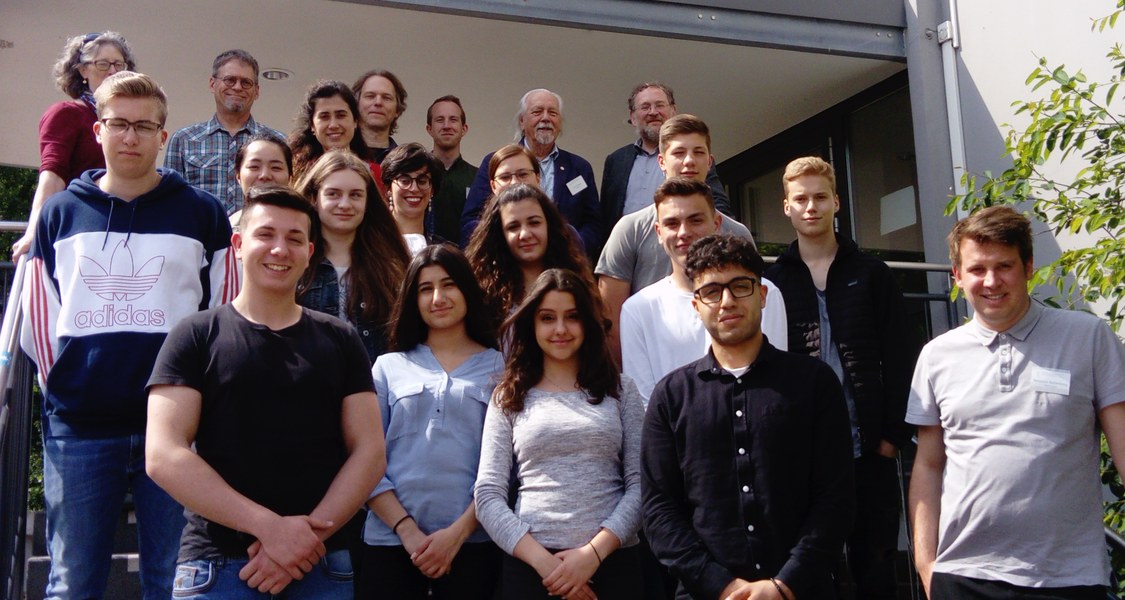 Ein Gruppenfoto von Menschen unterschiedlichen Alters, Geschlechts und Herkunft