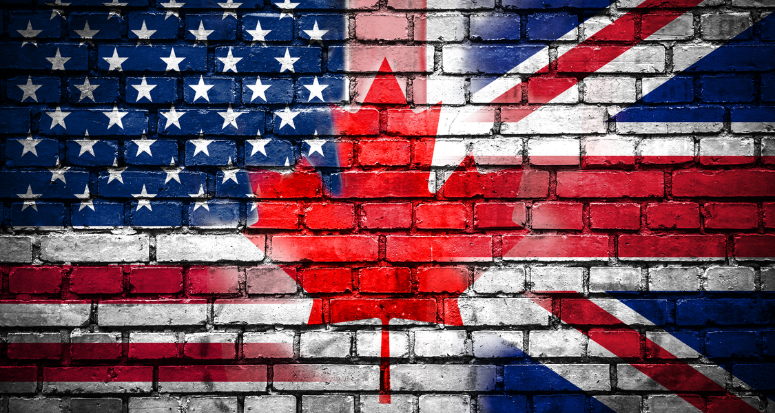 Flags for USA, GB and Canada on brick wall background, blended into one another