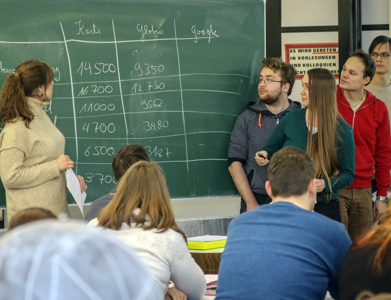 Studierende vor einer Tafel.