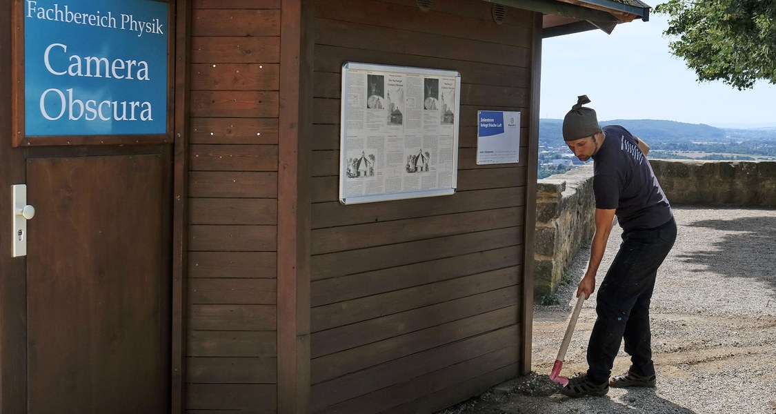 Teammitglied beim Freilegen der Lüftung der Camera Obscura