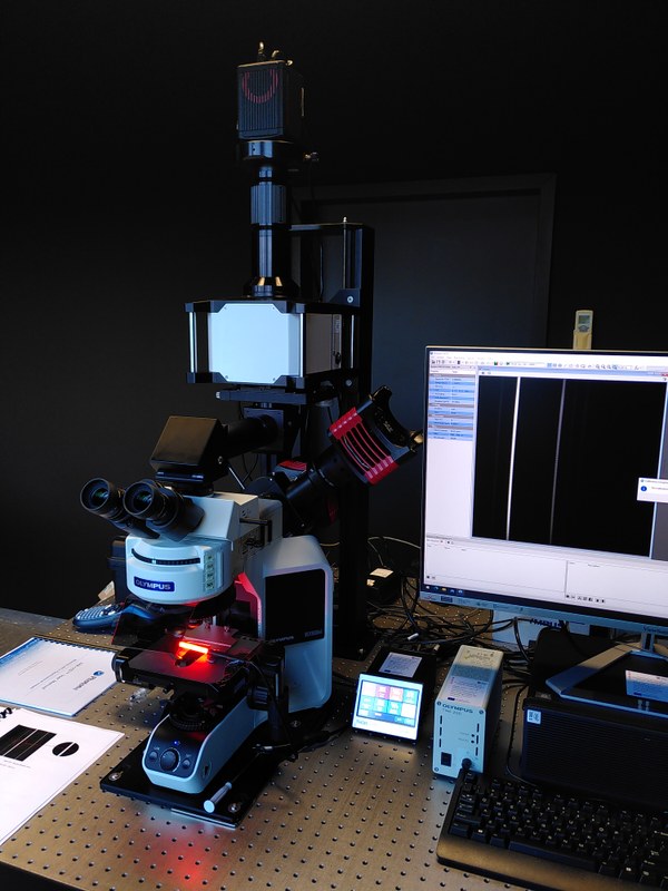 Das Foto zeigt ein Hyperspektrales Mikroskop, einen Bildschirm und diverse Messgeräte