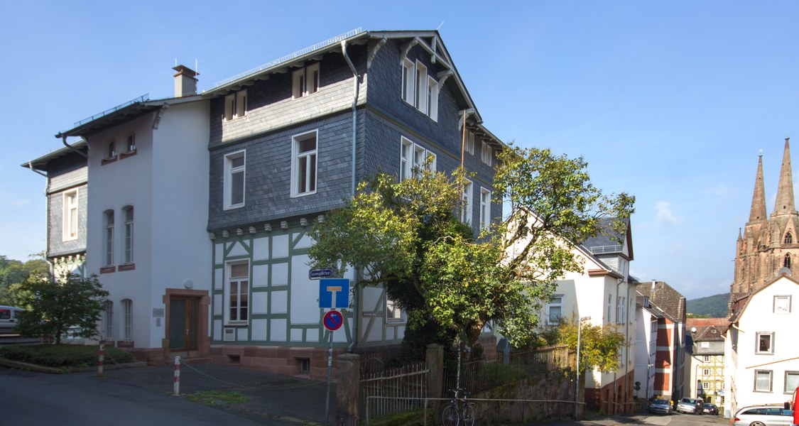 Bild des Institutsgebäudes im Roten Graben 10, Ecke Sauersgäßchen, in Marburg. Ansicht vom Roten Graben mit Elisabethkirche im Hintergrund.