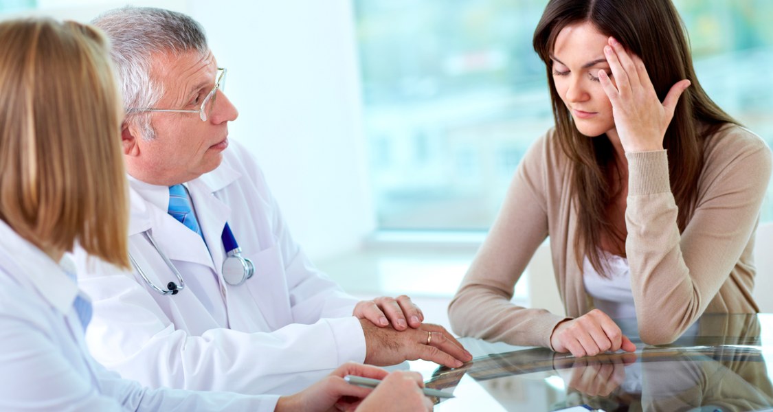 Portrait of two practitioners consulting patient