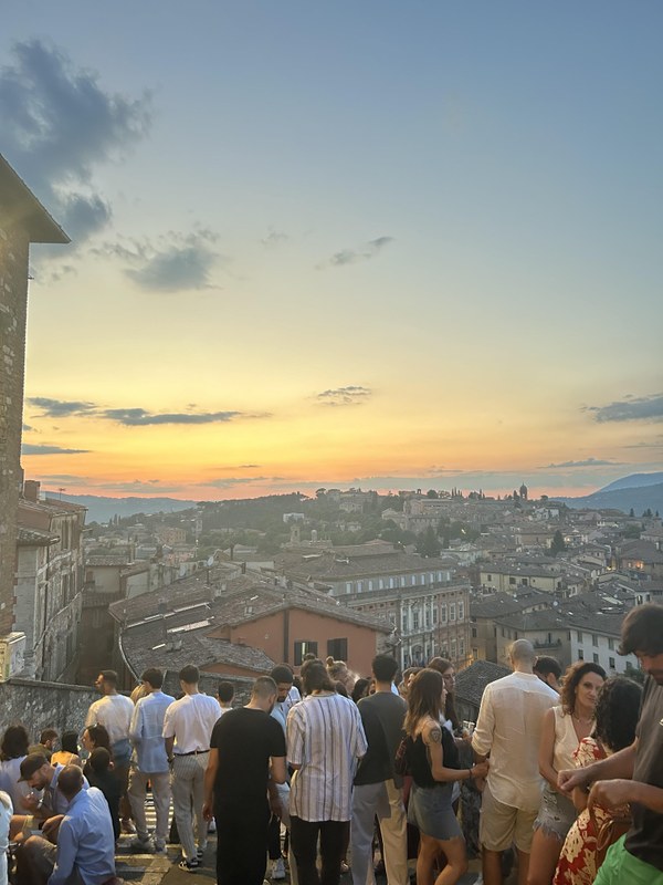 Auf dem Bild ist die Altstadt von Perugia bei Sonnenuntergang von einem Hügel aus zu sehen.