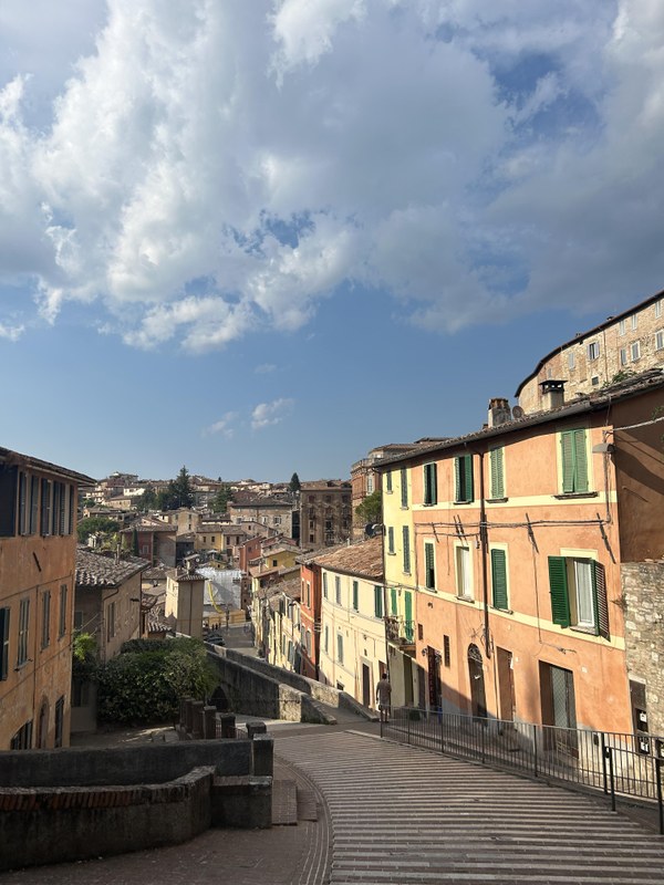 Kopfsteinplaster-Straße in der Altstadt von Perugia. An beiden Seiten Wohnhäuser.