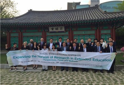 Viele Menschen stehen hinter einem großen Banner mit dem Titel "Expanding the Horizon of Research in Extended Education" und vor einem asiatisch anmutenden Häuschen. Unter anderem sind Frau Prof. Dr. Maschke und Herr Prof. Dr. Stecher zu erkennen.