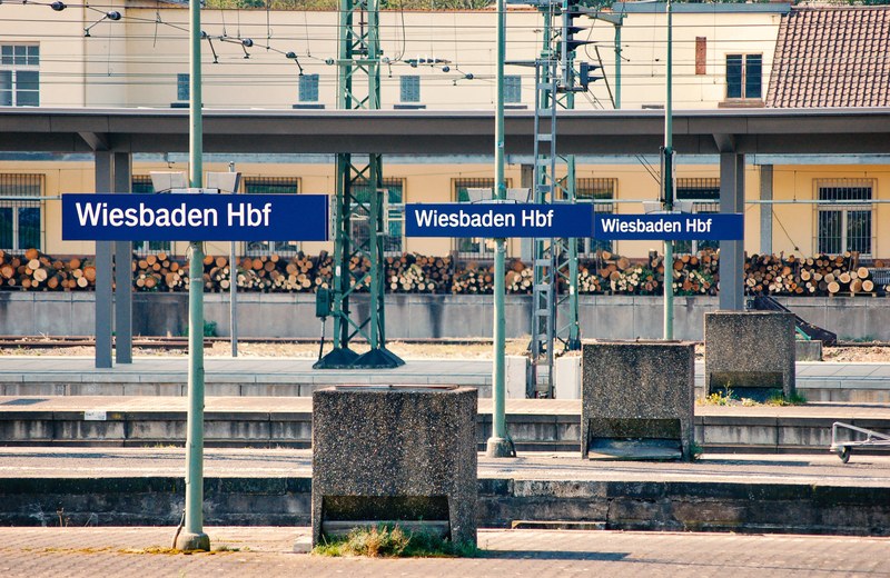 Zuggleise mit Ortsschildern am Bahnhof in Wiesbaden.