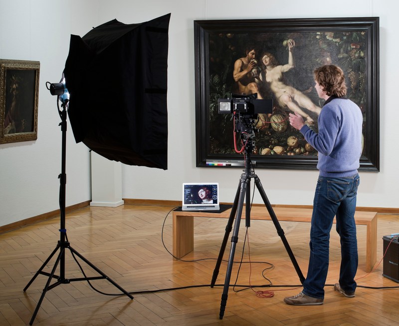 Ein großformatiges Gemälde wird von einer Person digital fotografiert.