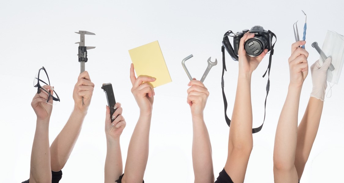 Hände mit verschiedenen Werkzeugen.