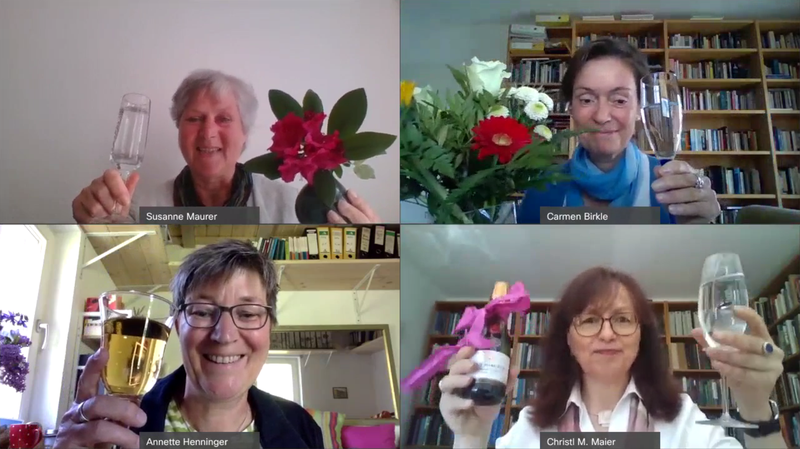 Susanne Maurer, Carmen Birkle, Annette Henninger und Carmen Birkle erheben Sektgläser in die Webcam und halten teils Blumen oder eine Sektflasche.