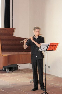 Junger Mensch spielt Flöte