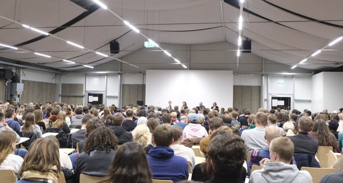 Blick über den Hörsaal mit Publikum und dem Podium.