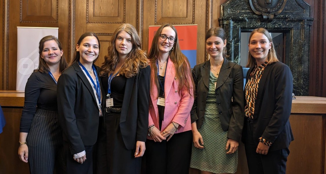 Das Marburger Nuremberg Moot Court-Team 2023 in Begleitung von Franziska Gruber und Laura Burmeister im Gerichtssaal 600 in Nürnberg.