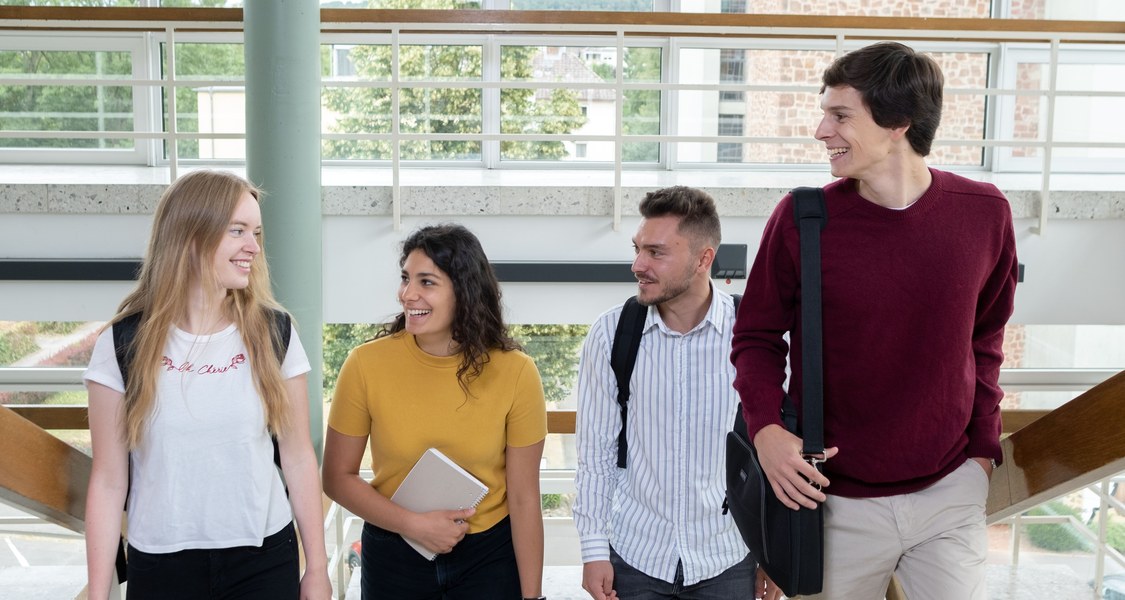 Studierendengruppe auf einer Treppe im Hörsaalgebäude