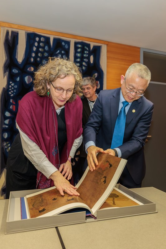 Blättern im Gastgeschenk: Die Vizepräsidentin der Uni Marburg, Prof. Dr. Evelyn Korn, und ihr Besuch Prof. Dr. Qiang Fu, stellvertretender Vorsitzender des Universitätsrats der Zhejiang-Universität (ZJU) aus Hangzhou, China.