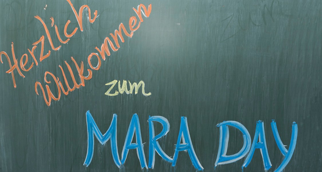 Auf einer Tafel steht "Herzlich Willkommen zum MARA DAY"