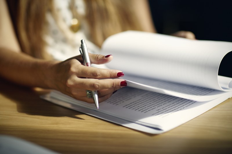 aufgeblättertes Heft, Hand mit Schreibstift