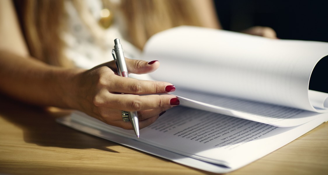 aufgeblättertes Heft, Hand mit Schreibstift