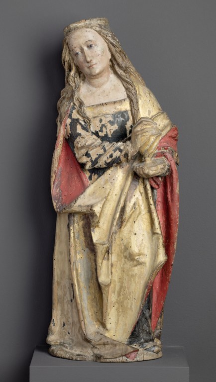 Relieffigur einer Frau mit langem, blondem Haar, Kopf und Blick leicht nach links unten geneigt. Sie hält ein Salbgefäß auf der rechten Seite über der Hüfte und trägt einen rot-goldenen Mantel.