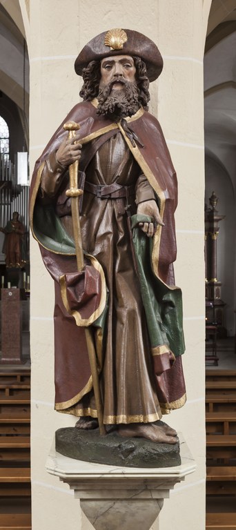Sakralraumskulptur des heiligen Jakobus dem Älteren im Pilgermantel, mit Wanderstab und Pilgerhut, frontal mit goldener Pilgermuschel, aus Hessen im Zeitraum um 1501 bis 1505.