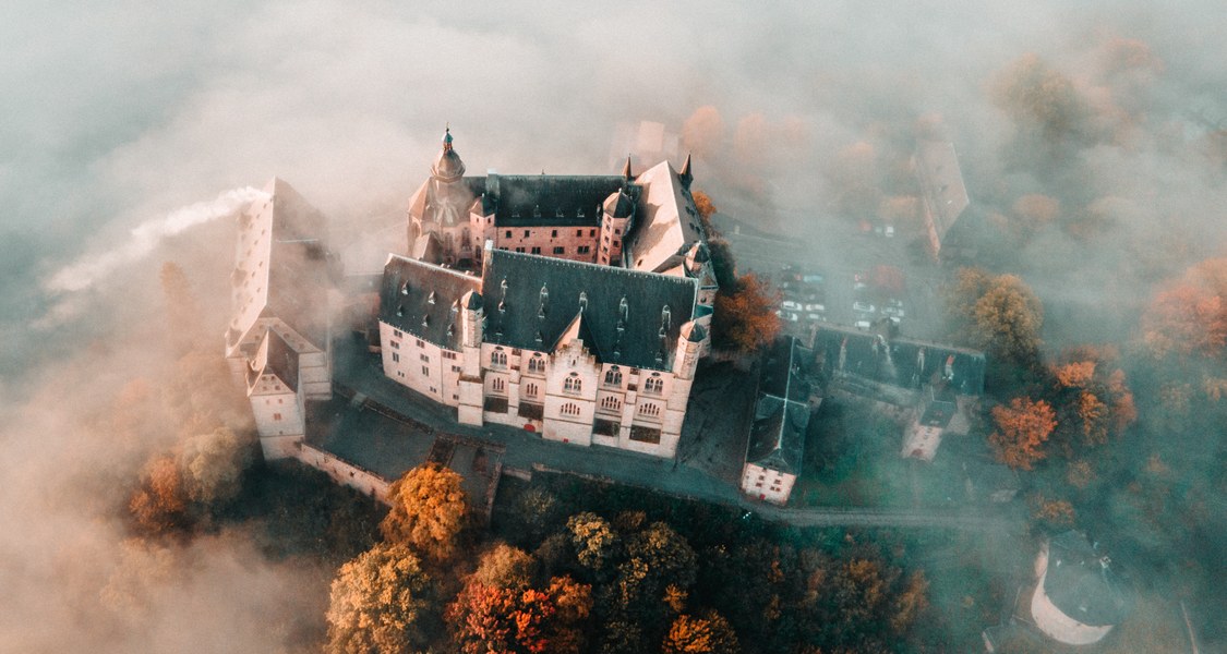 Luftaufnahme des Marburger Schlosses im Nebel