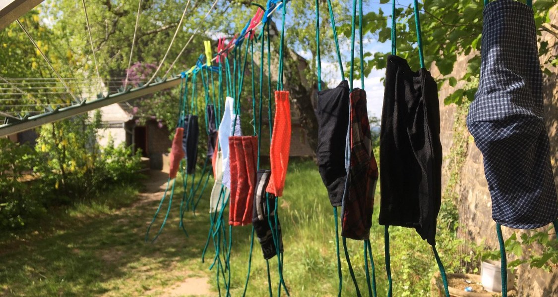 Selbstgenähte Mund-Nasenschutz Masken hängen auf der Wäscheleine im Paradiesgarten.