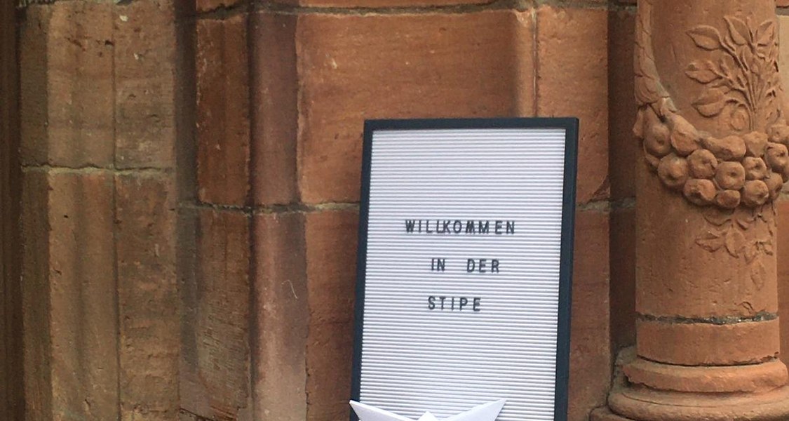 Das Letterboard steht vor dem historischen Eingang mit dem Schriftzug "Herzlich Willkommen in der Stipe".