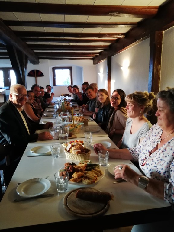 Weiteres Mittagessen im Speisesaal von Schloss 4. Viele Mitbewohner*innen an einer langen Tafel.