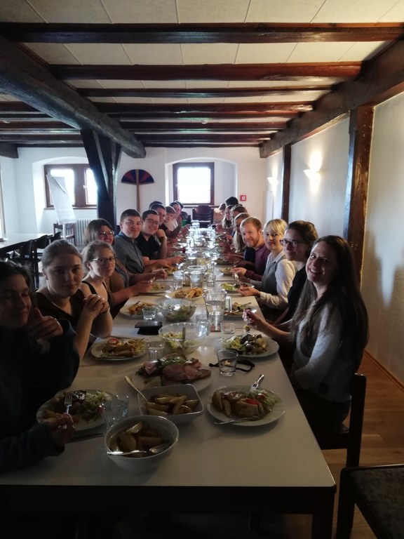 Weiteres Mittagessen im Speisesaal von Schloss 4. Viele Mitbewohner*innen an einer langen Tafel.