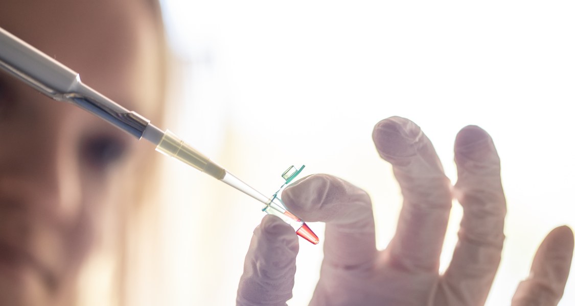 Doktorandin pipettiert Flüssigkeit in einem PCR-Gefäß zusammen.