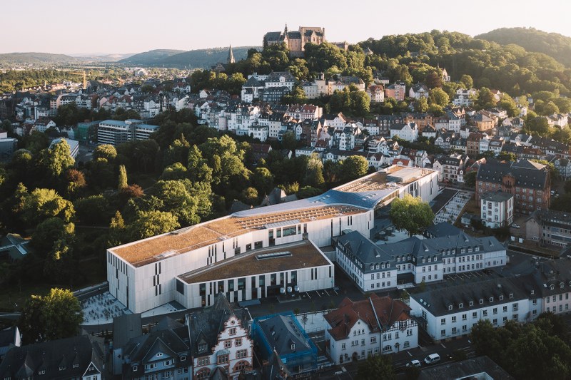 Das Bild zeigt eine Luftaufnahme von Marburg. Zu sehen sind das Schloss und die neue Uni-Bibliothek.