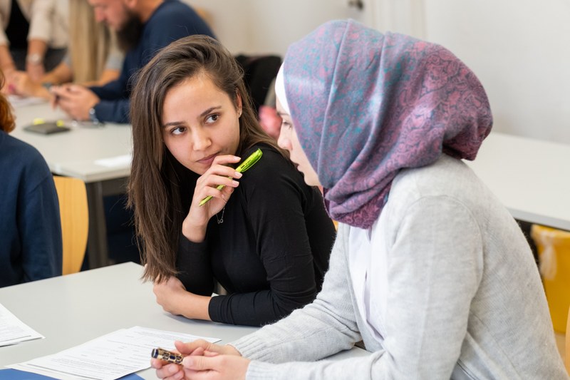 Zwei Studentinnen arbeiten gemeinsam an einem Arbeitsblatt.