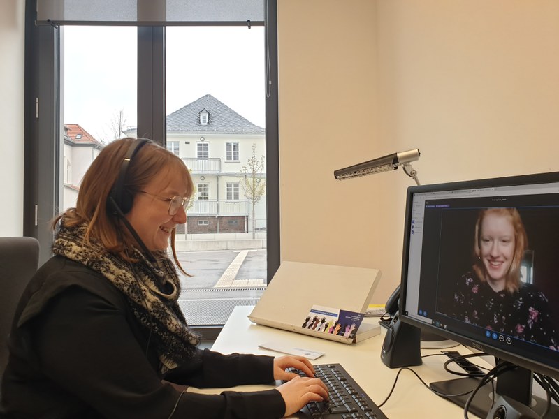 Studienhelferin sitzt vor einem PC-Bildschirm und berät eine Ratsuchende online.