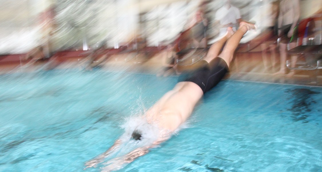 Mann springt in ein Schwimmbecken