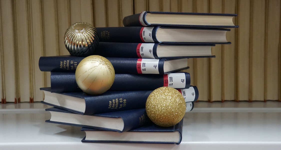 Bücherstapel mit drei Adventskugeln