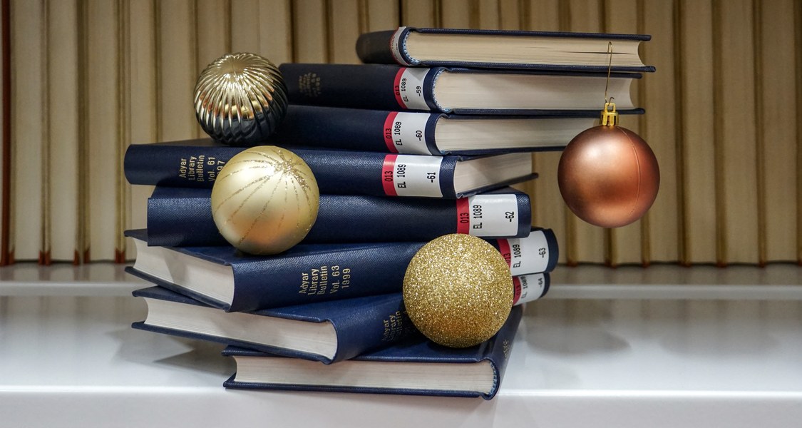 Bücherstapel mit vier Adventskugeln