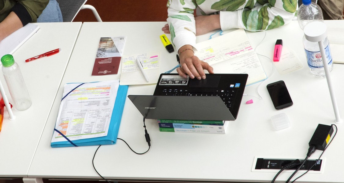 Studierende mit Laptops in der UB