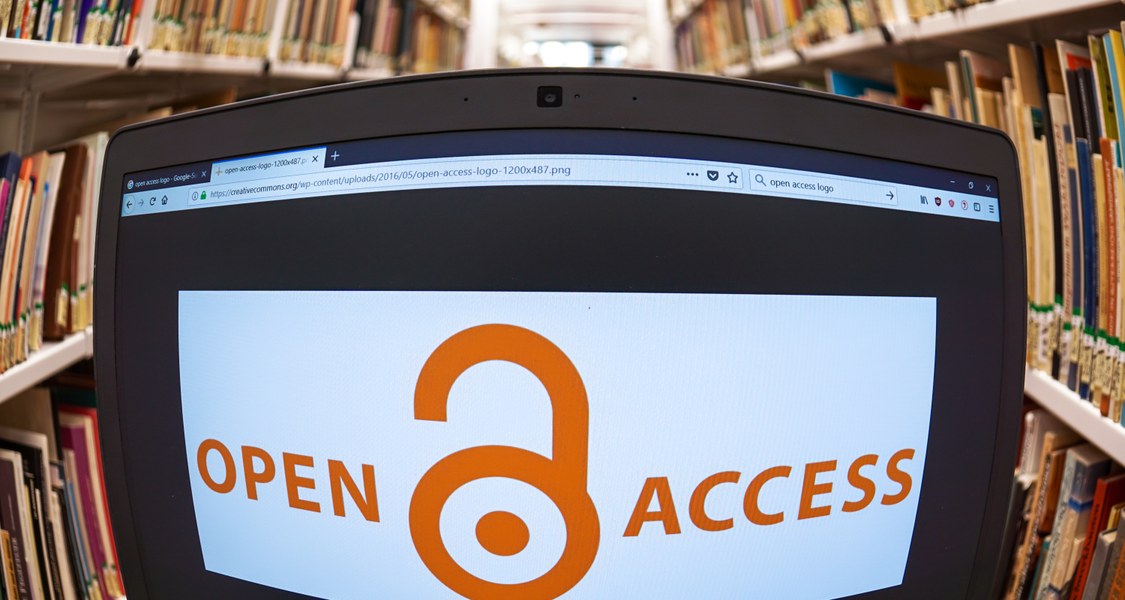 Bildschirm mit Open Access Logo zwischen Bücherregalen