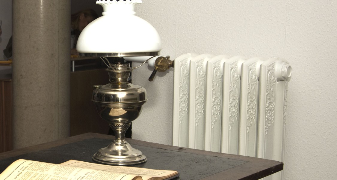 Alter Beistelltisch mit Leselampe und aufgeschlagenem Buch