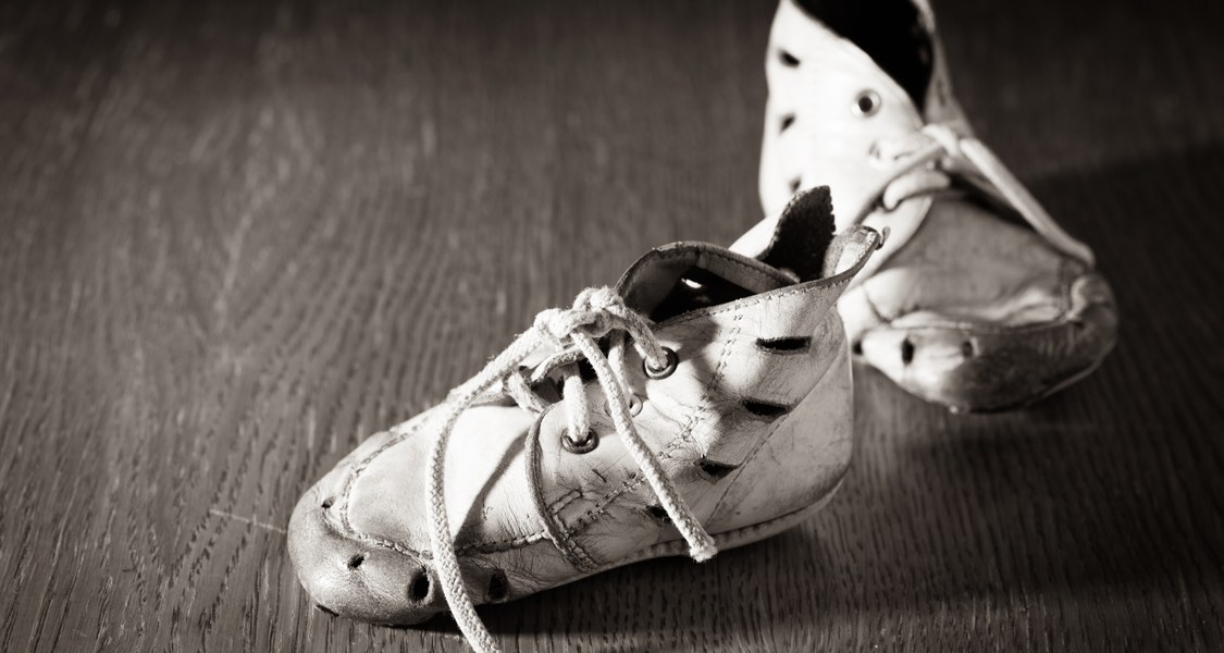 Schwarzweiß-Aufnahme von alten Kinderschuhen.