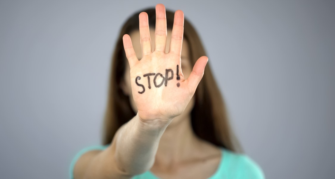 abwehrende Handbewegung mit dem Schriftzug "Stop!"