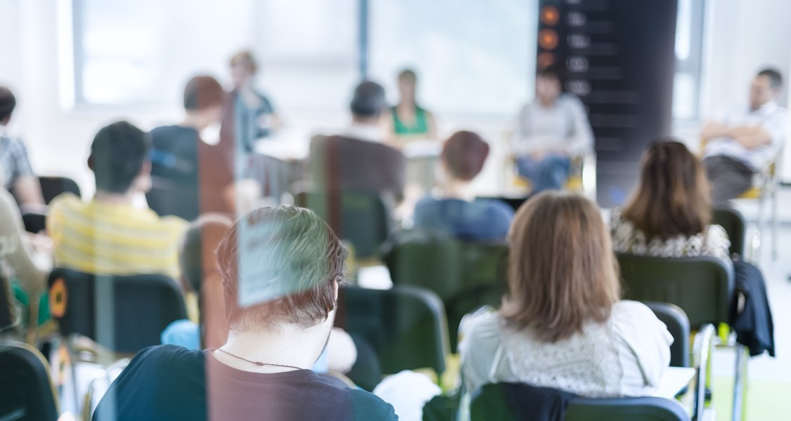 Das Publikum lauscht dem Handeln in einer Konferenzhalle