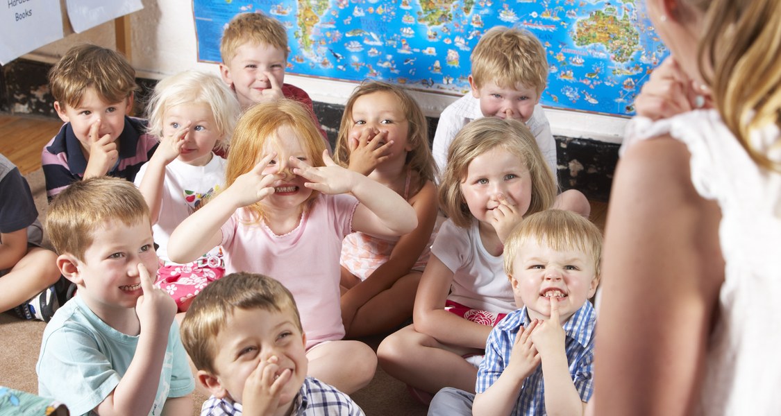 Kindergruppe im Kindergarten SCHNEIDET Grimassen: