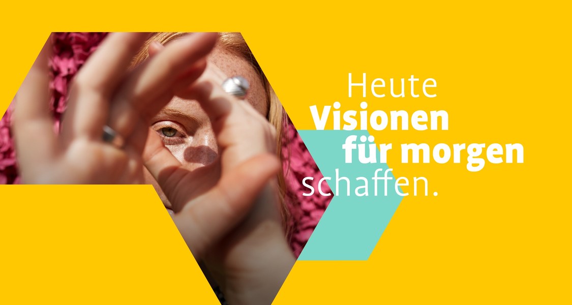 Studentin formt mit ihren Händen ein Fernglas, durch das sie schaut. Text: Heute Visionen für morgen schaffen.