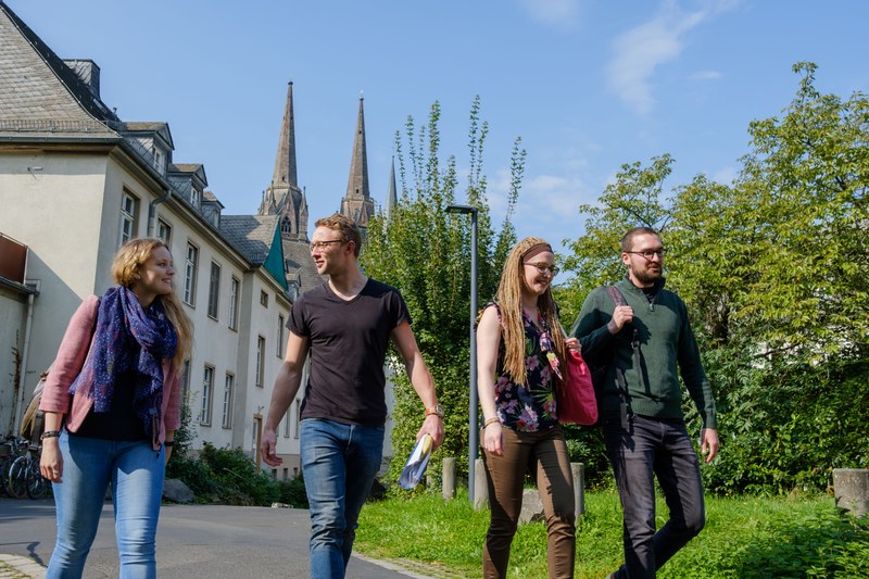 Studierende gehen über den Innenhof des Carolinenhauses