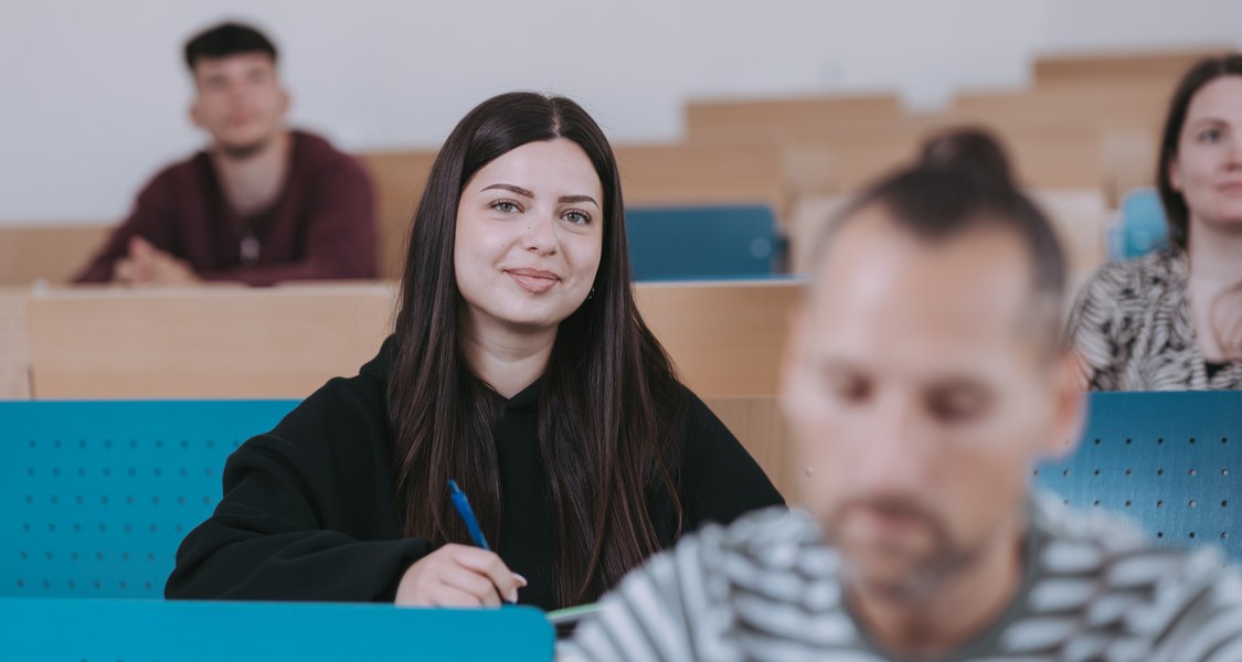 Studierende im Hörsaal, Fokus auf einer Studentin