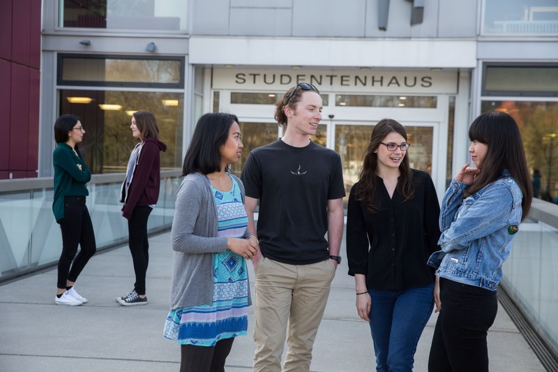 Studierende unterhalten sich auf der Mensabrücke