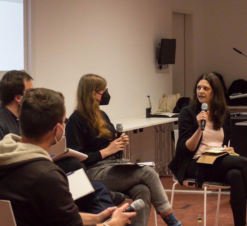 Vier Menschen diskutieren bei der Podiumsdiskussion vorne.