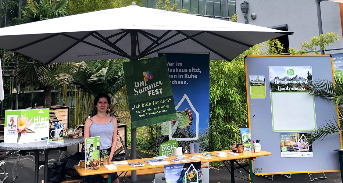 Das Foto zeigt den Infostand der Spendenkampagne "Ich blüh für dich" beim Uni-Sommerfest der Philipps-Universität im Botanischen Garten auf den Lahnbergen.