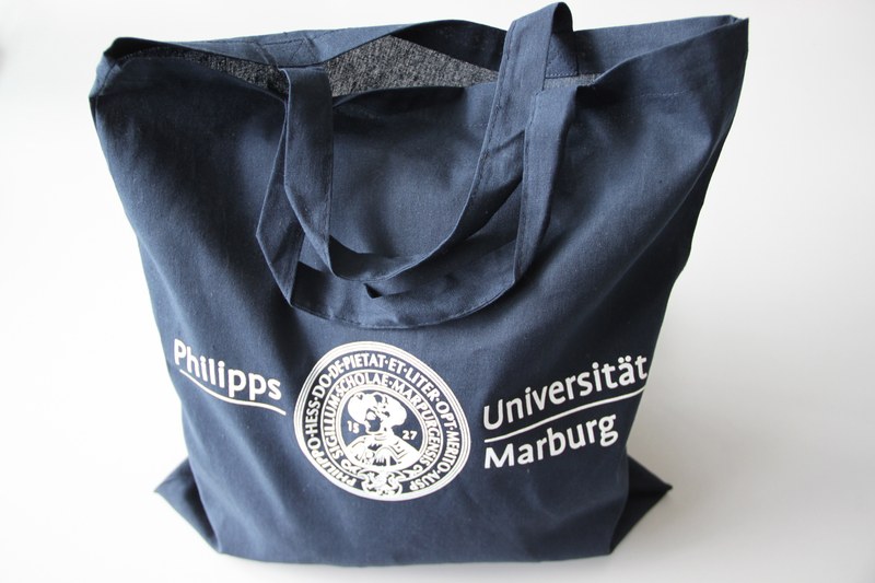 blaue Baumwolltasche mit dem alten Logo der Philipps-Universität Marburg
